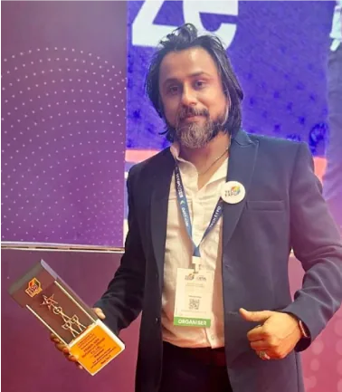 Pinakin Soni holding an award